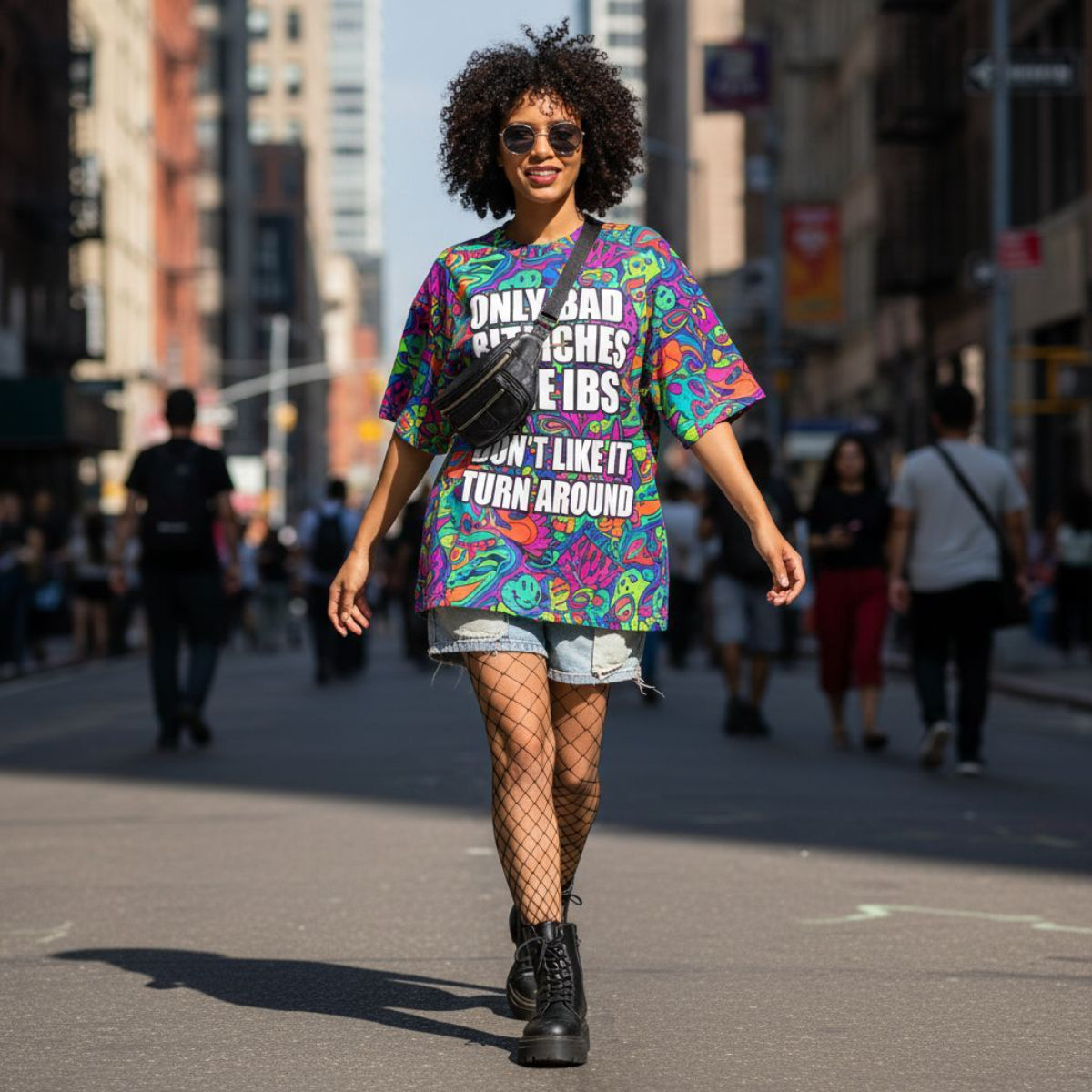 Woman walking on a city street wearing a colorful graphic t-shirt.